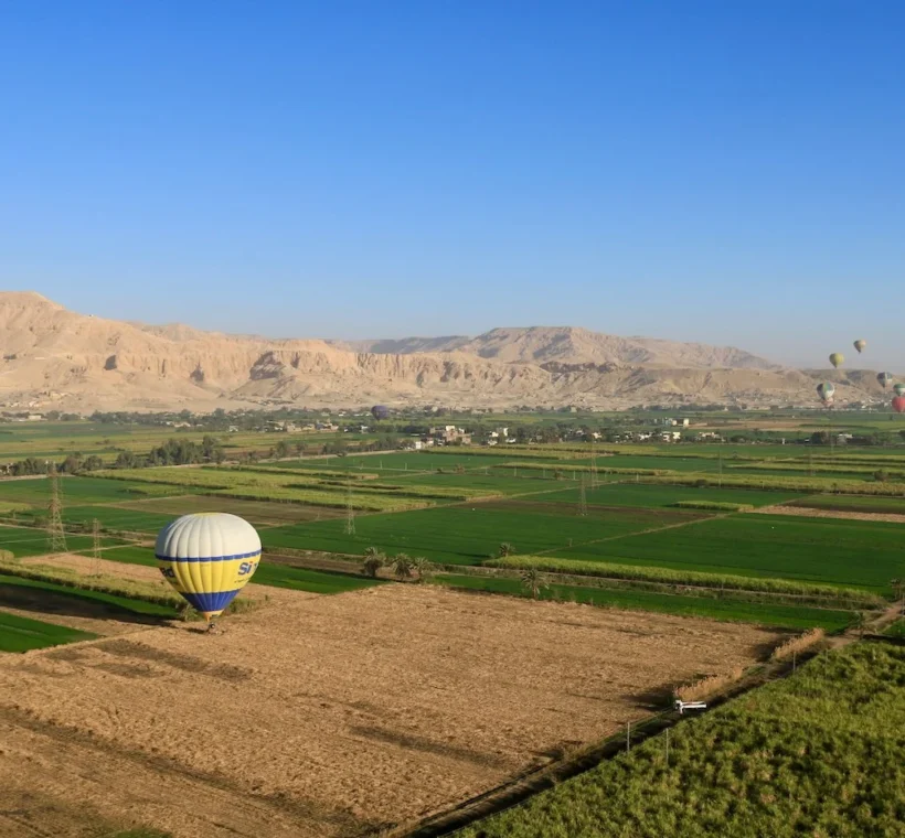Montgolfi&egrave;re survolant les champs verdoyants et la vall&eacute;e du Nil &agrave; Louxor au lever du soleil